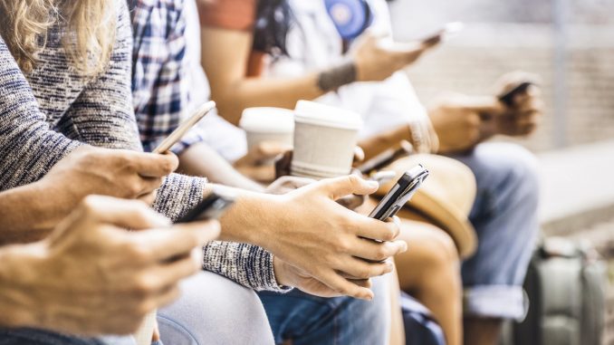 Multicultural friends group using smartphone with coffee at univ